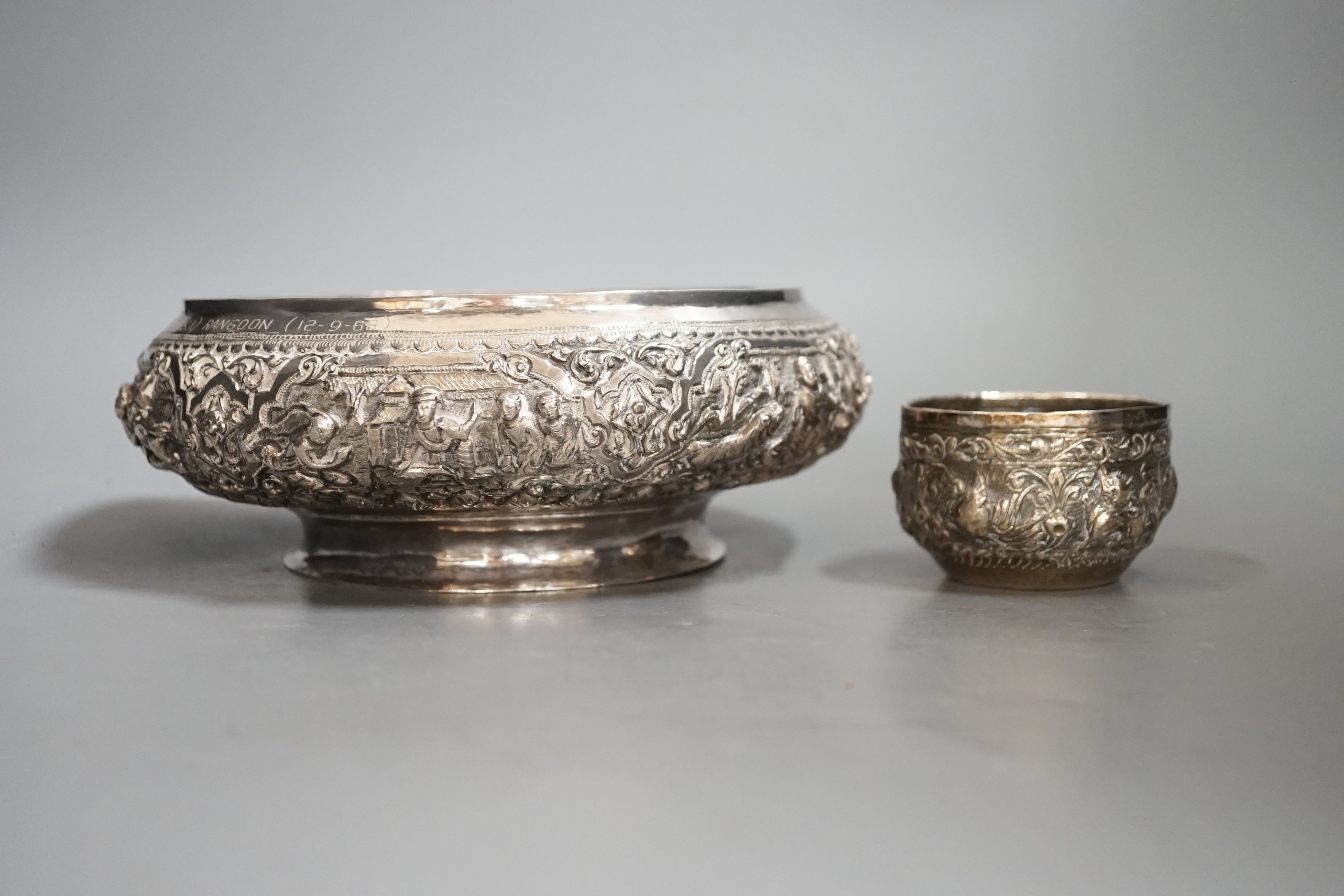 An Indian repousse white metal presentation bowl, with engraved inscription, diameter 21.5cm and a similar smaller bowl